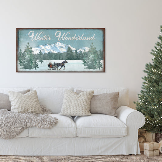 May include: A vintage-style sign with the text &#39;Winter Wonderland&#39; in white cursive lettering on a blue background. The sign depicts a snowy landscape with a horse-drawn sleigh and pine trees. The sign has a brown wooden frame.